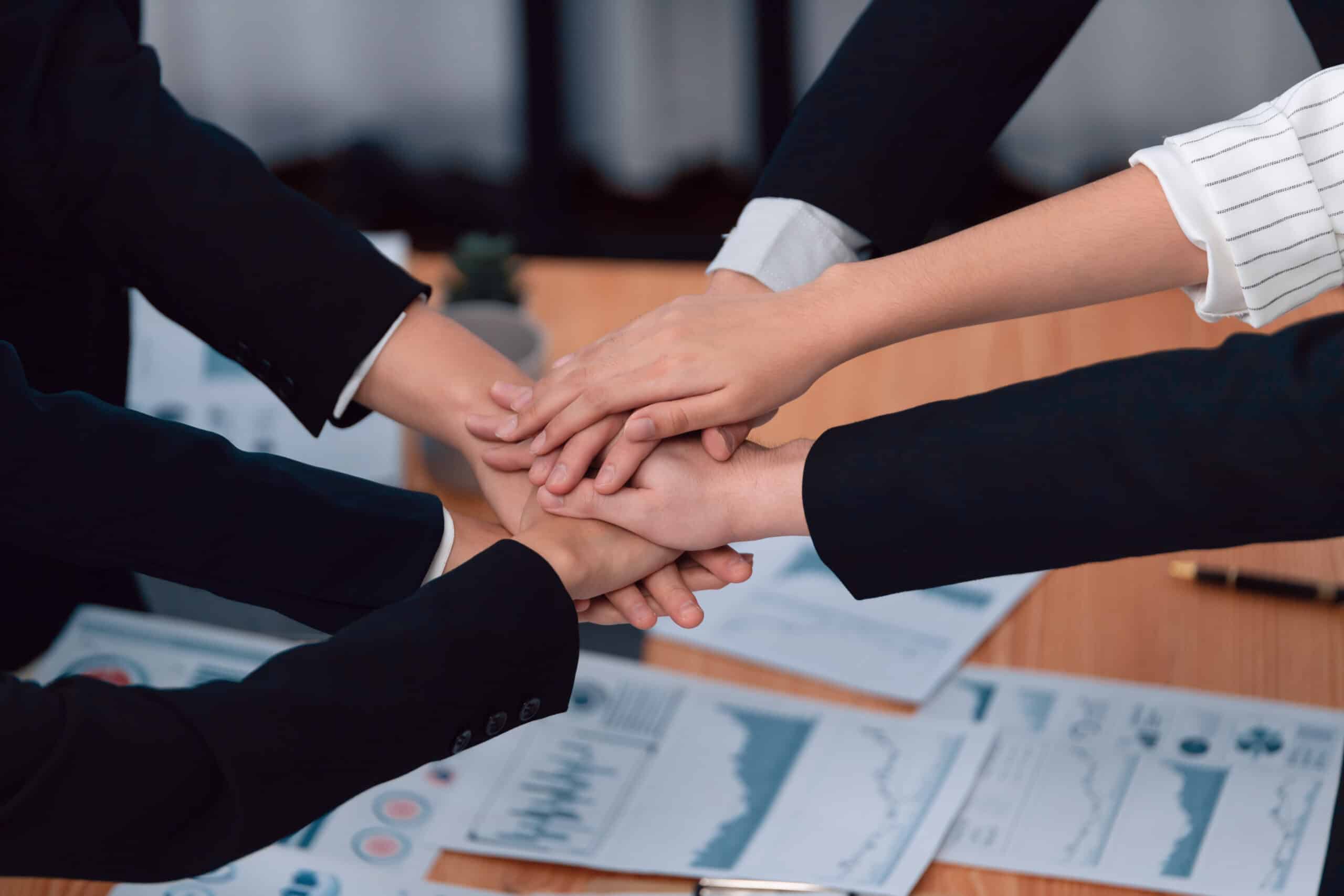 49887024_top-view-closeup-business-team-join-hand-stack-together-for-harmony-concept-scaled.jpg