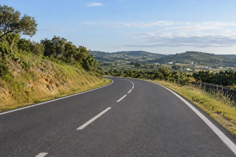 Free asphalt road, with a smooth curve in a rural landscape.