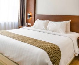black sconce beside white bed