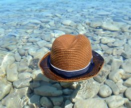 brown and black fedora hat on gray stone